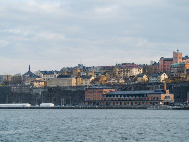 Bulutlu gökyüzüne karşı nehir kıyısındaki binaların görüntüsü
