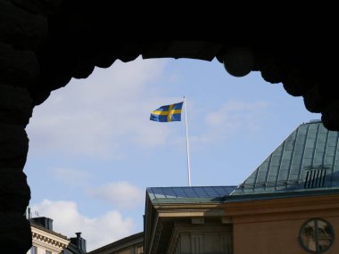 Gökyüzüne karşı bina yaparak dalgalanan bayrağın düşük açılı görüntüsü