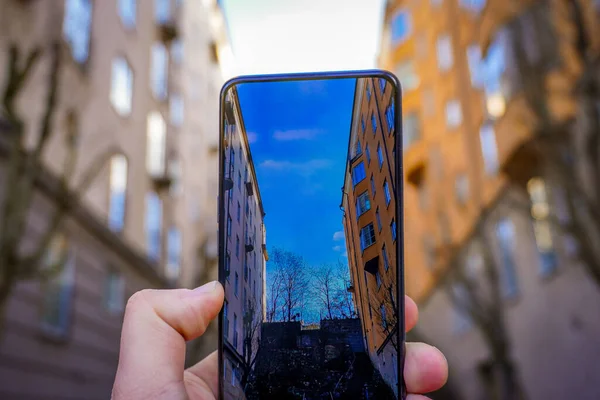 Şehirdeki binalara karşı cep telefonuyla kesilmiş el fotoğrafları.