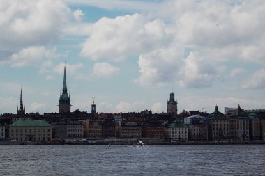 Bulutlu gökyüzüne karşı nehir kıyısındaki binaların görüntüsü