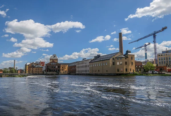 stock image View of buildings by river against cloudy sky