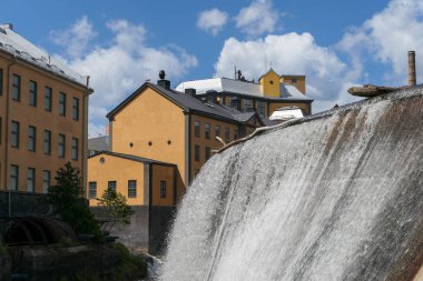 Şehirdeki binaların önünde bir şelale 