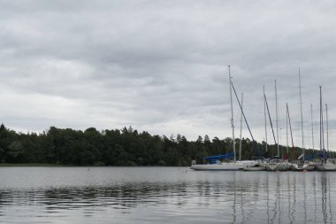 Bulutlu gökyüzüne karşı marinadaki yelkenli manzarası 