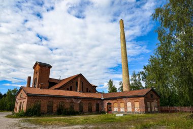 Bulutlu gökyüzüne karşı terk edilmiş eski sanayi binasının manzarası