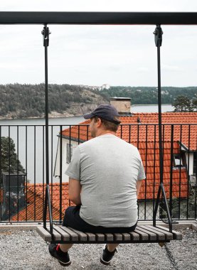 Gökte salıncakta sallanan adamın dikiz görüntüsü