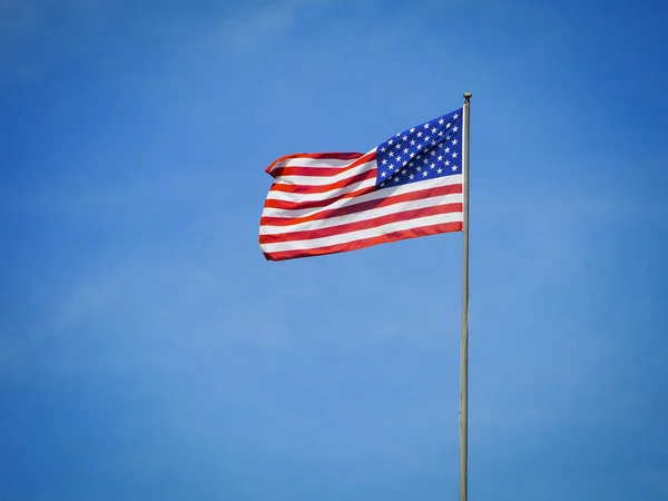 青い空に対するアメリカ国旗の低角度表示 ロイヤリティフリーのストック画像