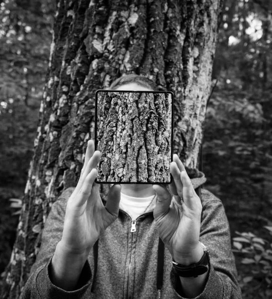 Ένα Άτομο Που Στέκεται Μπροστά Από Ένα Δέντρο Κρατώντας Μια — Φωτογραφία Αρχείου