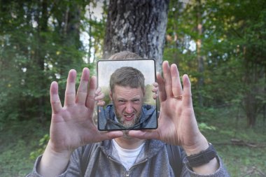 İçinde kendisi olan bir çerçeveyi tutan adamın portresi. 