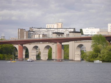 Bulutlu gökyüzüne karşı nehrin üzerindeki köprü görüntüsü