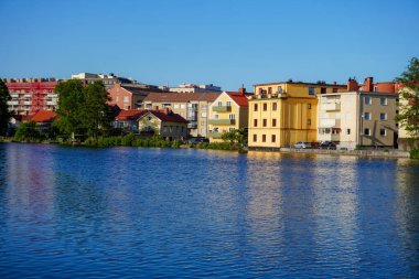 Mavi gökyüzüne karşı nehir kıyısındaki binaların manzarası