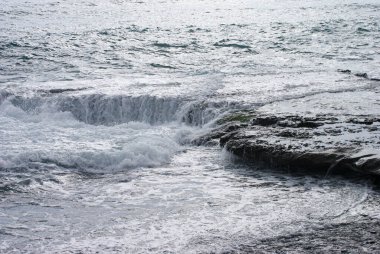 High angle view of waves splashing on rocks