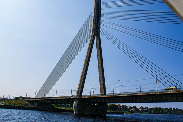 Low angle view of bridge over river against clear blue sky