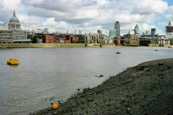 Bulutlu gökyüzüne karşı nehir kıyısındaki binalar 
