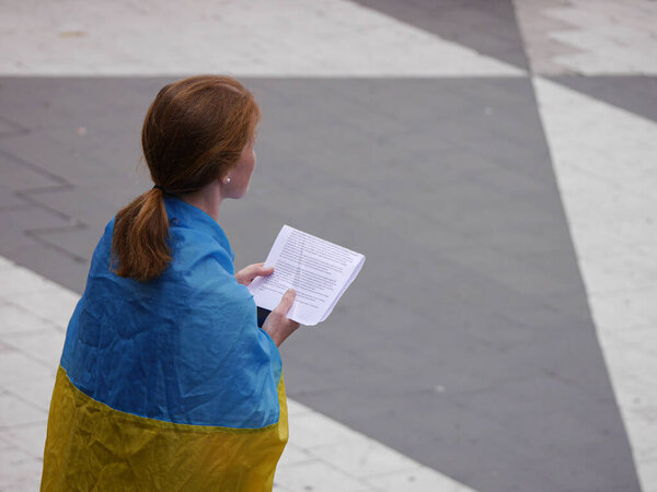 Высокий угол обзора женщины, держащей бумагу, стоя на площади 