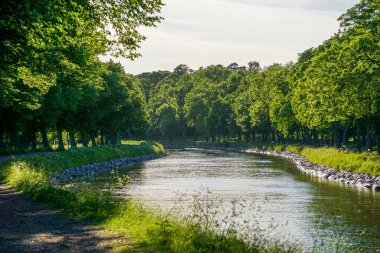 Scenic view of canal amidst trees against sky