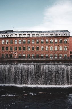 Tuğla binanın önünde bir şelale. 