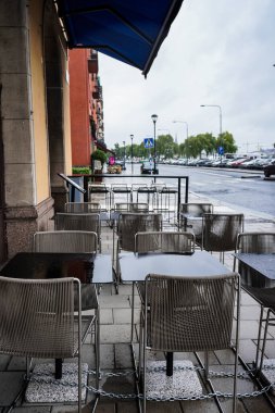 Empty chairs and tables at sidewalk cafe