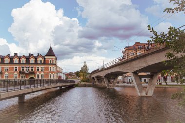 Bulutlu gökyüzüne karşı nehir üzerindeki köprülerin görüntüsü