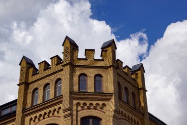 Bulutlu gökyüzüne karşı tuğla bir binanın alçak açılı görüntüsü 