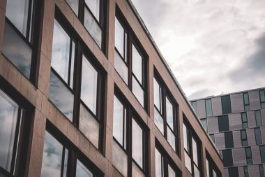 Bulutlu gökyüzüne karşı modern binaların alçak açılı görüntüsü 