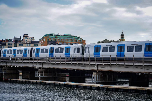 Şehirdeki bir nehri aşan köprüde giden bir tren. 