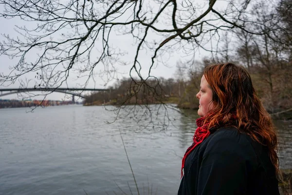 Stock image Side view of woman looking away while standing by river during winter