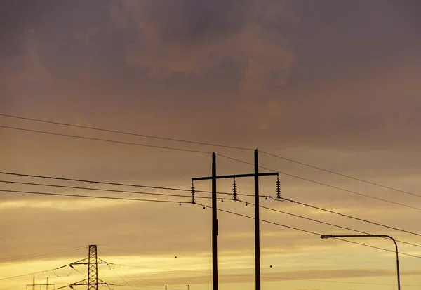日没時の空に対する電気パイロンの低角度ビュー — ストック写真