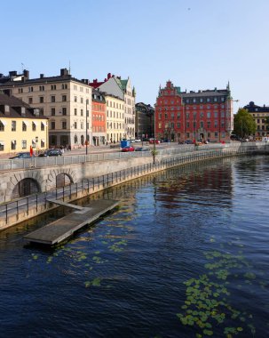 View of buildings by river against clear sky
