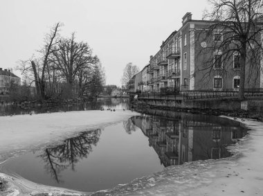 Kışın gölün yanındaki binalar 