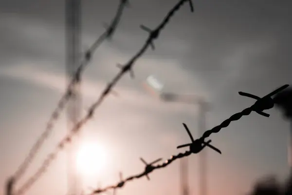 Close up of barbed wire against the sky