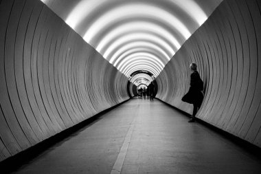 Tünelde duvara dayanmış bir kadın. 