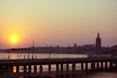 Gün batımında nehirden nehre uzanan siluet köprü