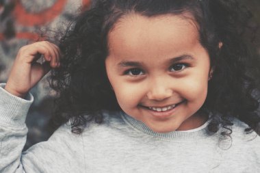 Kıvırcık saçlı tatlı bir kızın portresi. 