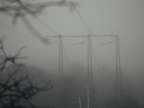 View of electric power transmission during a foggy day
