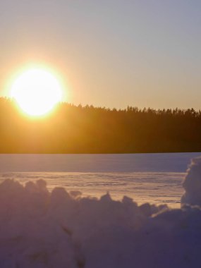 Gün batımında karla kaplı bir tarla 
