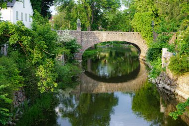 Şehirdeki bir kanalda eski bir taş köprü manzarası 