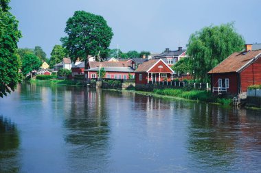 Buildings by a river during summer  clipart