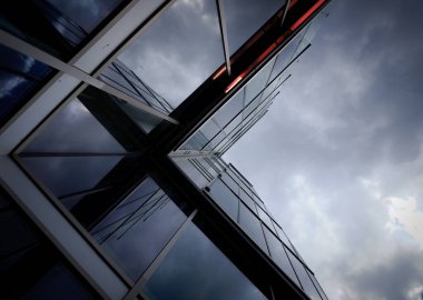 Bulutlu gökyüzüne karşı modern bir binanın alçak açılı görüntüsü 