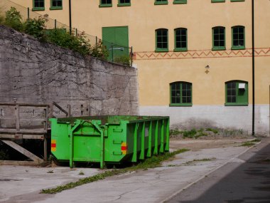 Avluda yeşil bir konteyner.