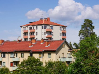 Gökyüzüne karşı apartman binaları ve ağaçlar 