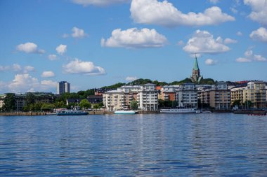 Bulutlu gökyüzüne karşı deniz kıyısındaki binaların görüntüsü
