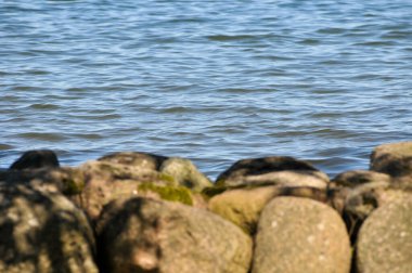 Göl kıyısındaki kayaların yakınına.