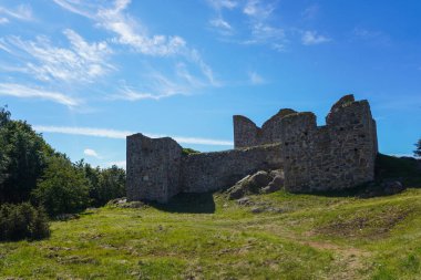 Çimenli bir arazisi olan büyük bir taş kalıntısı.