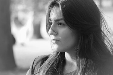 Siyah beyaz giymiş genç bir kadının portresi. 