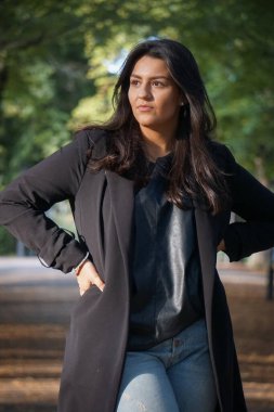 Parkta duran genç bir kadın. 