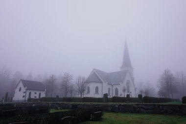 Sisli bir günde bir kilise ve mezarlık. 
