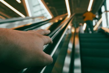 Yürüyen merdivene binen birine yakın plan.