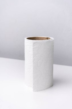 Tuvalet kağıdı beyaz ve gri arkaplanda yuvarlanıyor