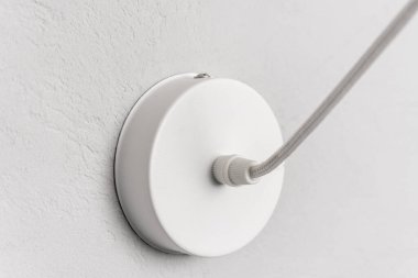Gri arkaplandaki kolye lambası için beyaz elektrik prizi, yakın plan