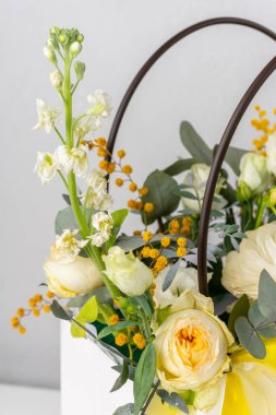 Bir buket çiçek ve yeşillik poşetin içinde.